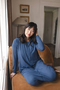 Modal posing in Adult Sleep Bag Walker in Oxford sitting on brown sofa