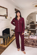 Modal standing in a living room wearing Long-Sleeved Women's Pajama Set in Burgundy with Burgundy Trim
