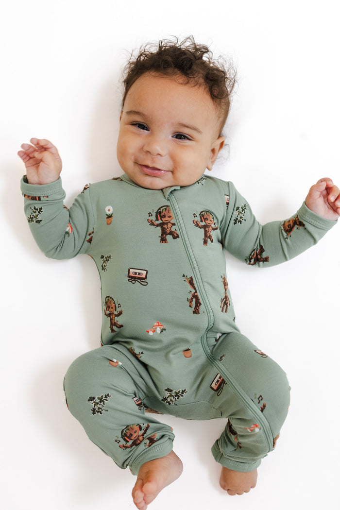 Baby wearing Green Zippered Romper in Groot print on a white background